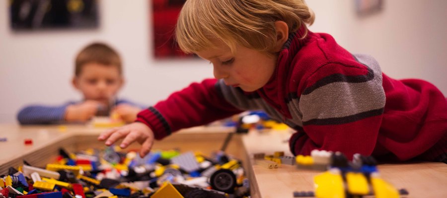 Child playing with lego Slider Image